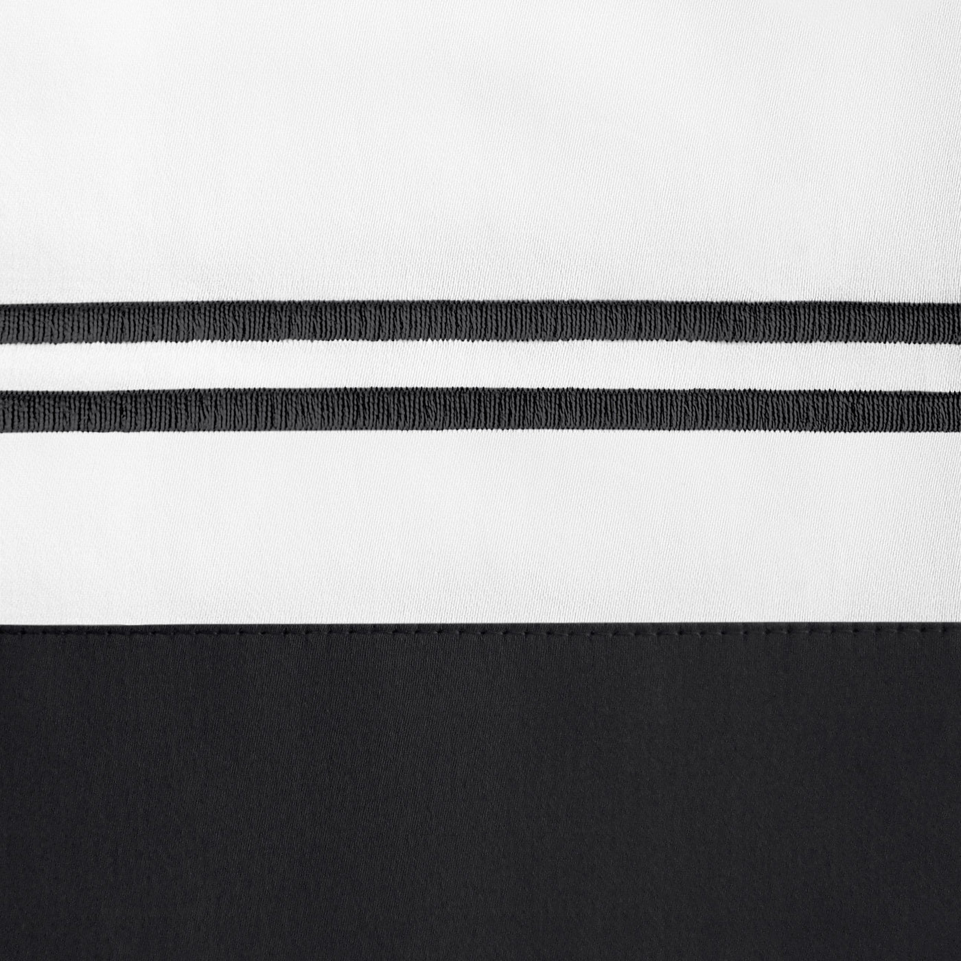 Close-up of ivory and onyx color-block border with twin embroidered stripe detail.