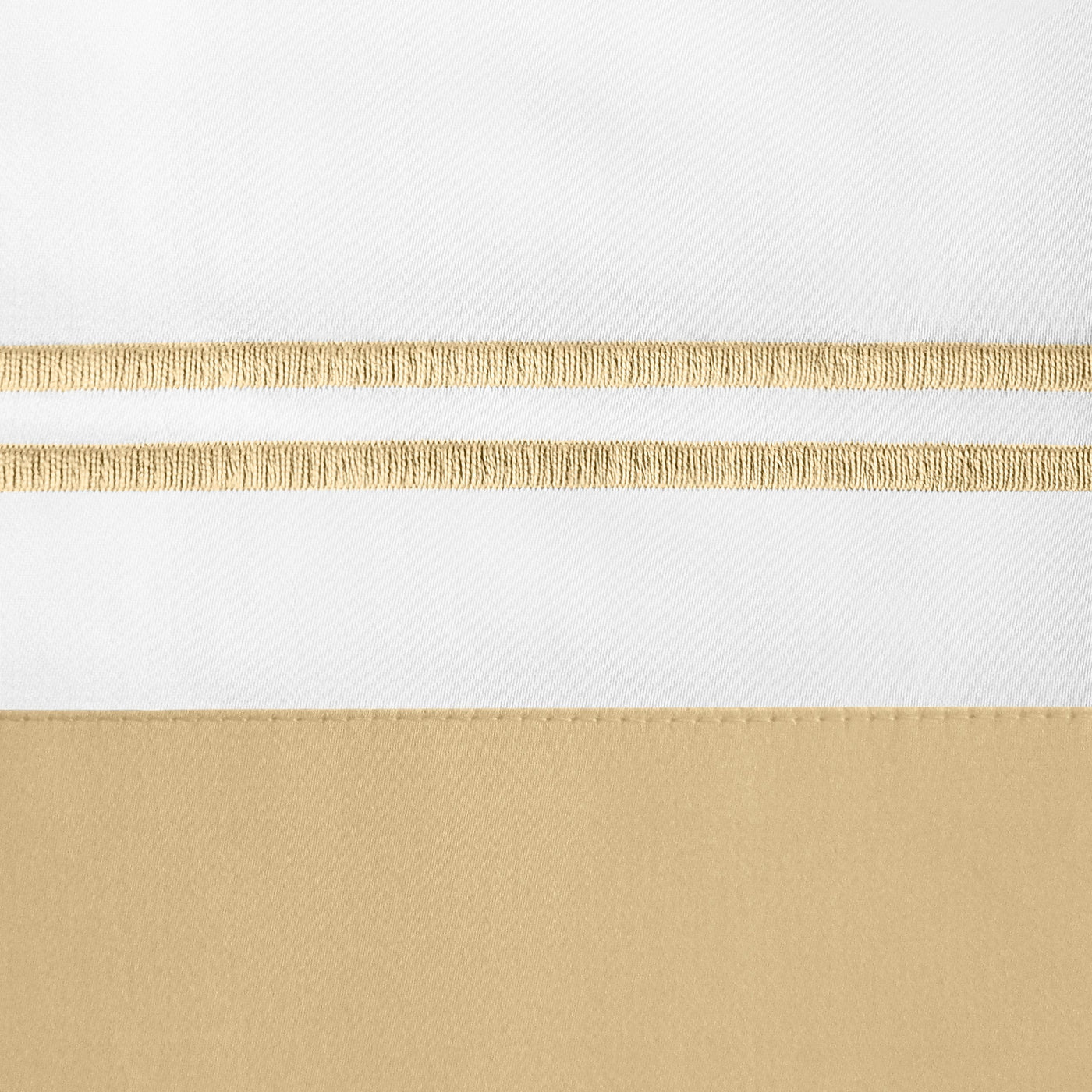 Close-up of white and champagne linen duvet cover with metallic gold embroidered stripe detail.