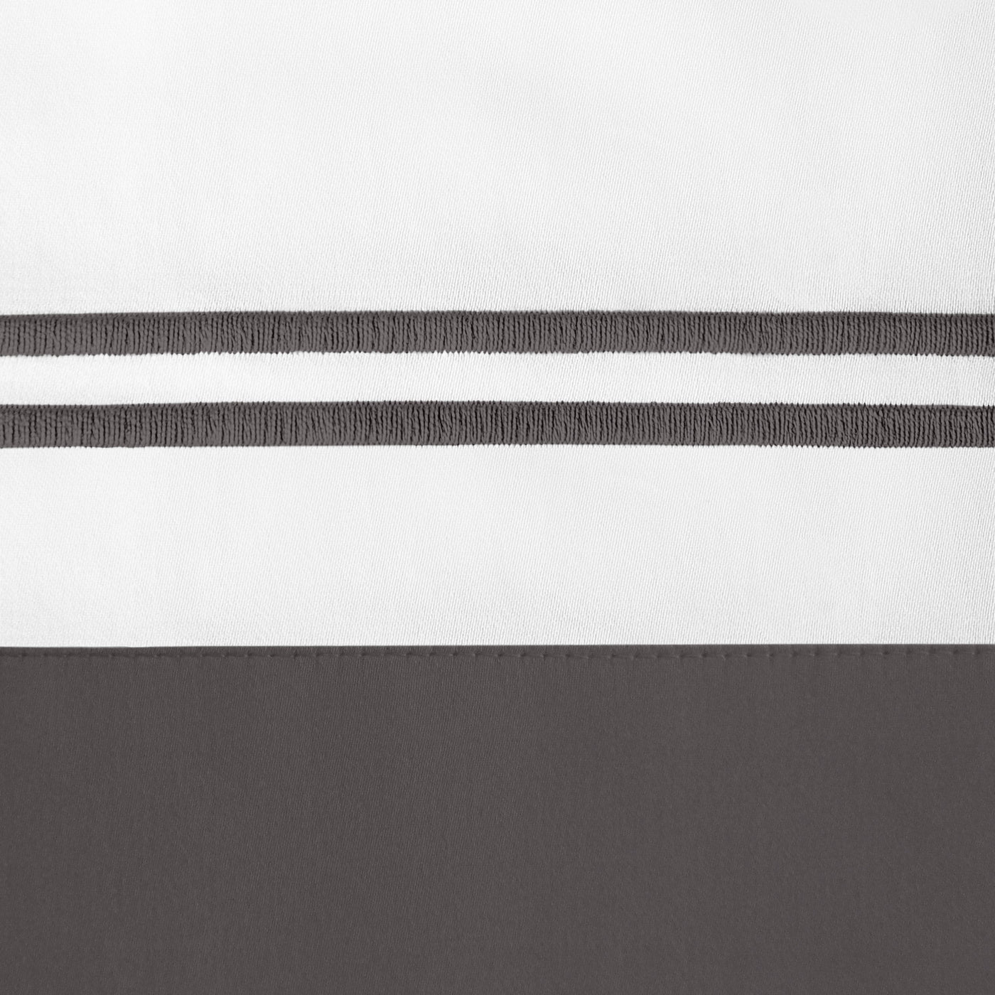 Close-up of white and charcoal colorblock linen with dual embroidered stripe border detail.
