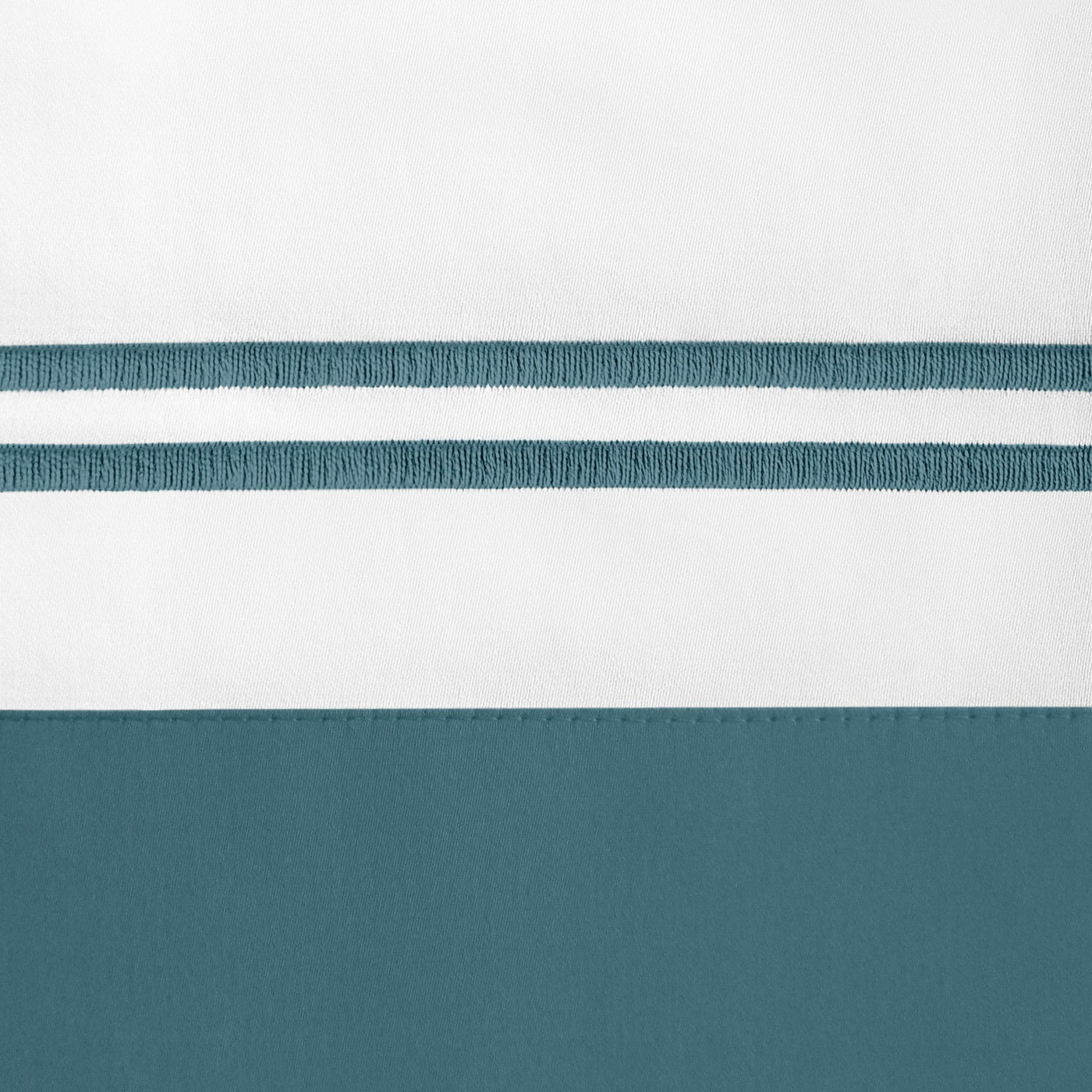 Close-up of teal embroidered double stripe detail on white and teal cotton fabric border.