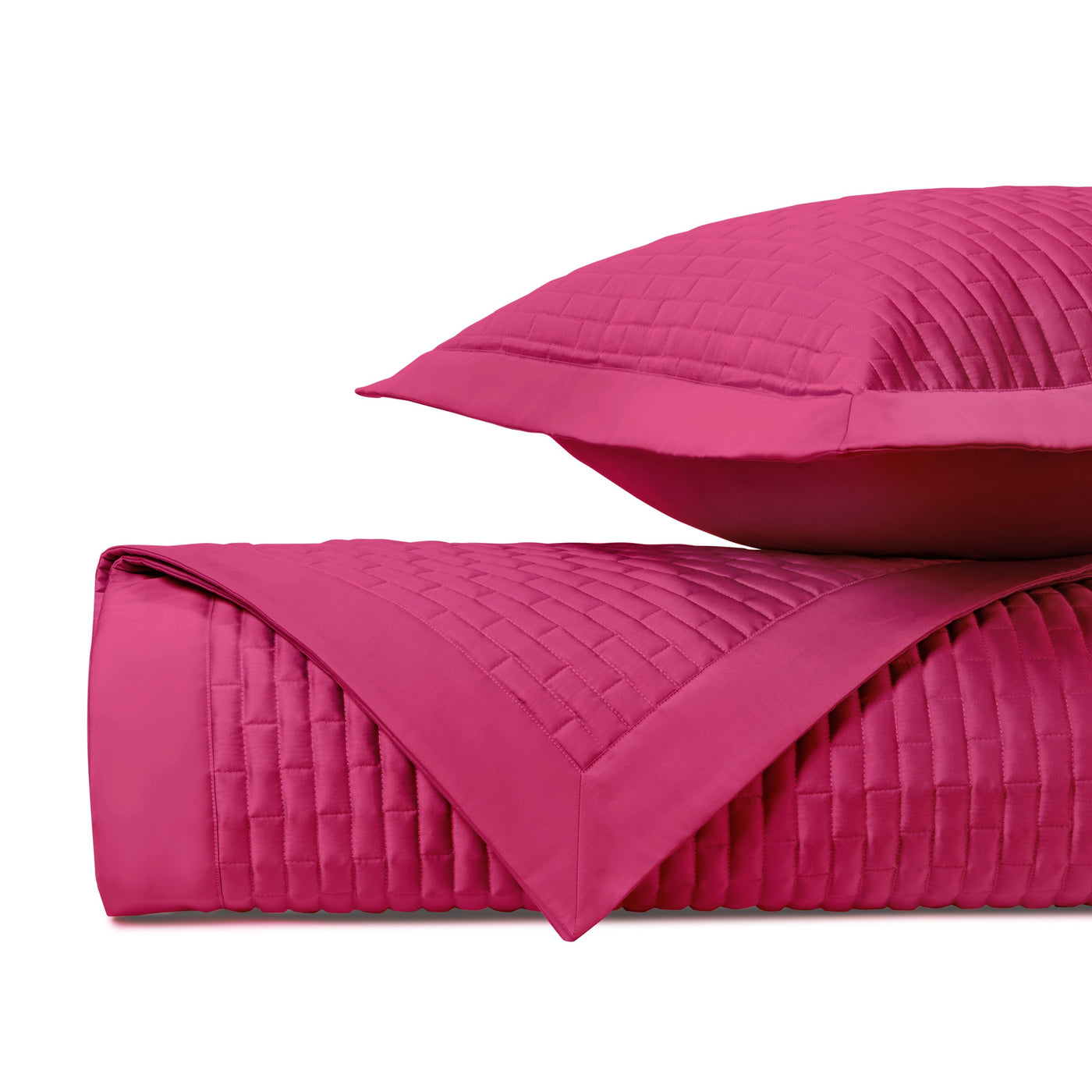 Fuchsia quilted coverlet and sham, folded to show basket-weave stitching pattern.