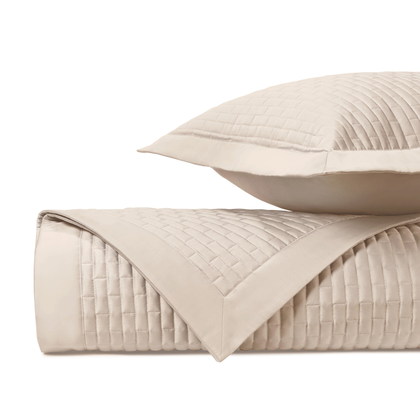 Close-up of Mason quilted texture in ivory, showing basket-weave stitching on folded coverlet and sham.