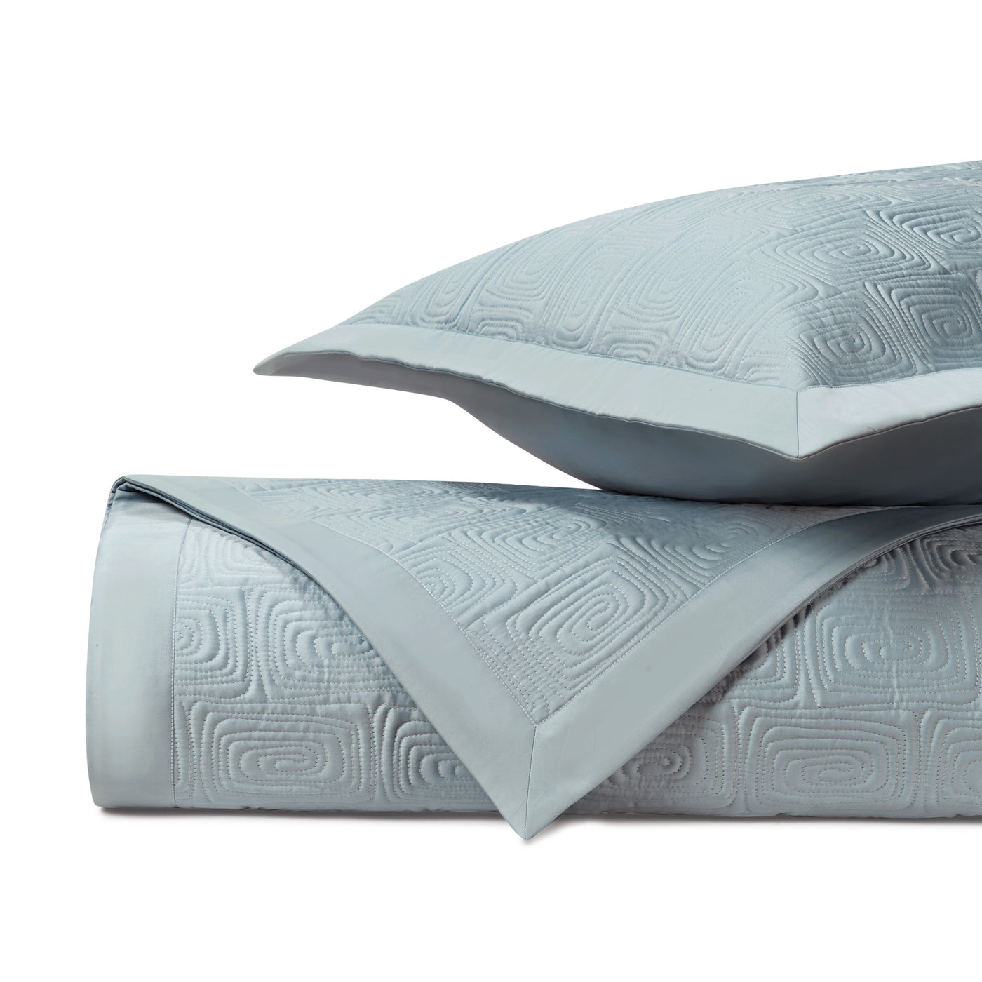 Close-up of Home Treasures Maze quilted coverlet in mist blue with geometric relief pattern.