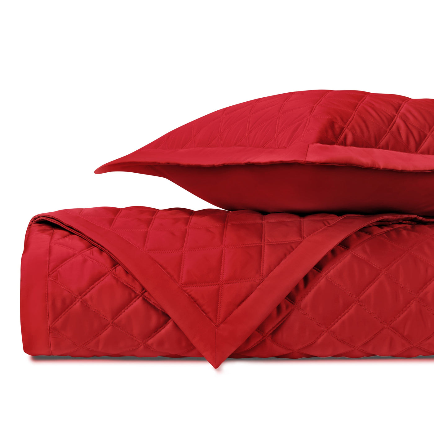 Close-up of crimson quilted diamond-stitched coverlet and sham, folded.