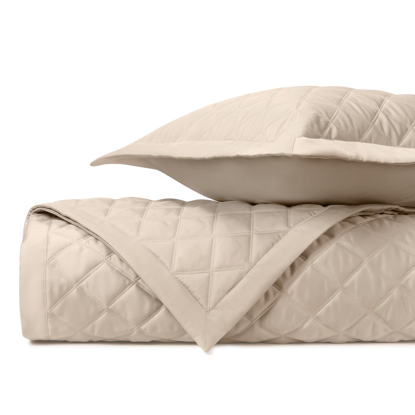 Close-up of Mesa quilted satin weave in champagne with diamond stitching pattern.
