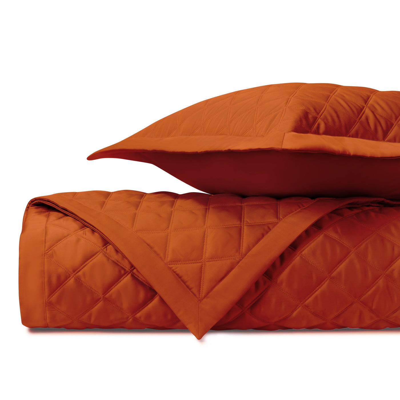 Close-up of Home Treasures Mesa quilted satin in burnt orange diamond stitching pattern.
