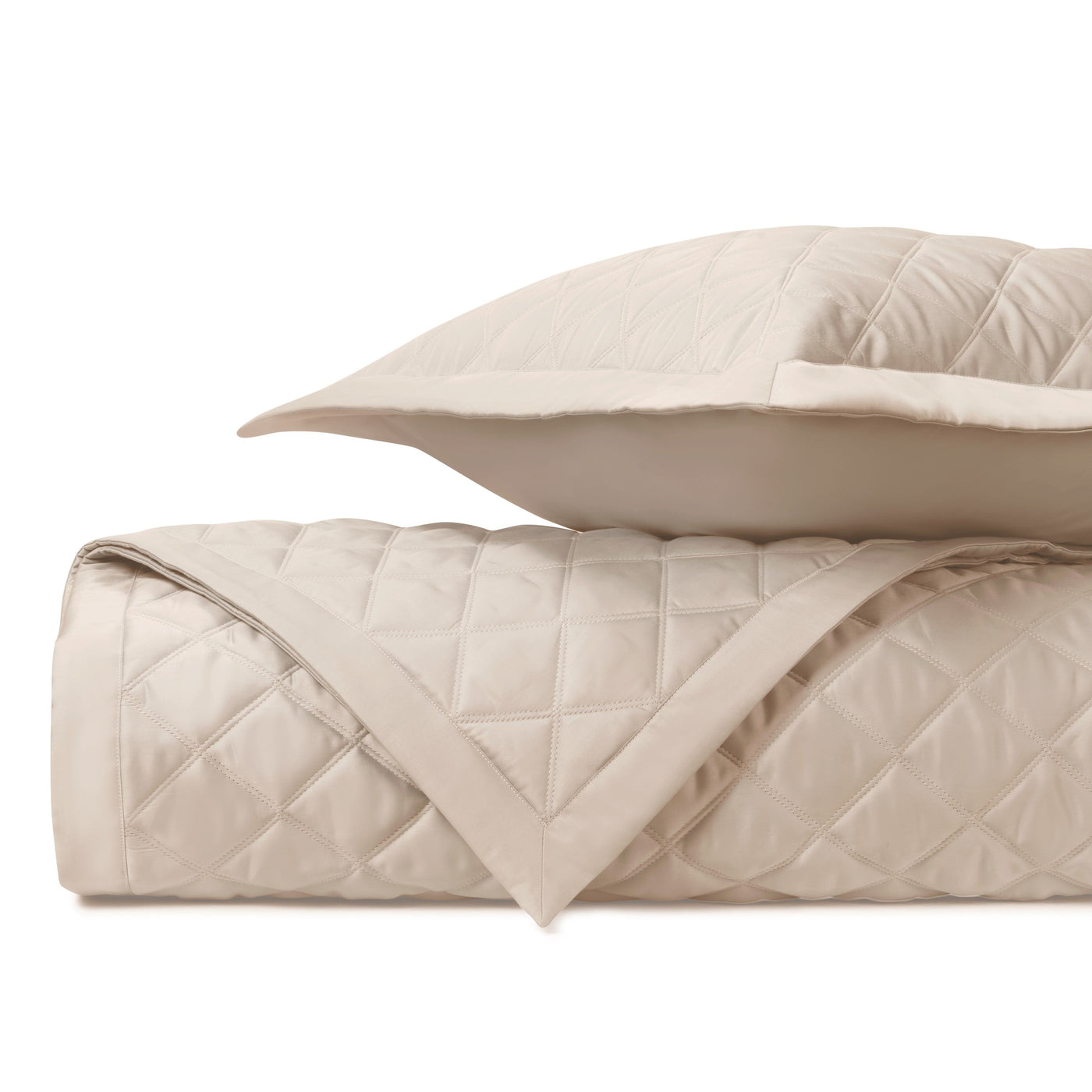 Close-up of Mesa quilted satin in champagne, showing diamond stitching pattern and border detail.