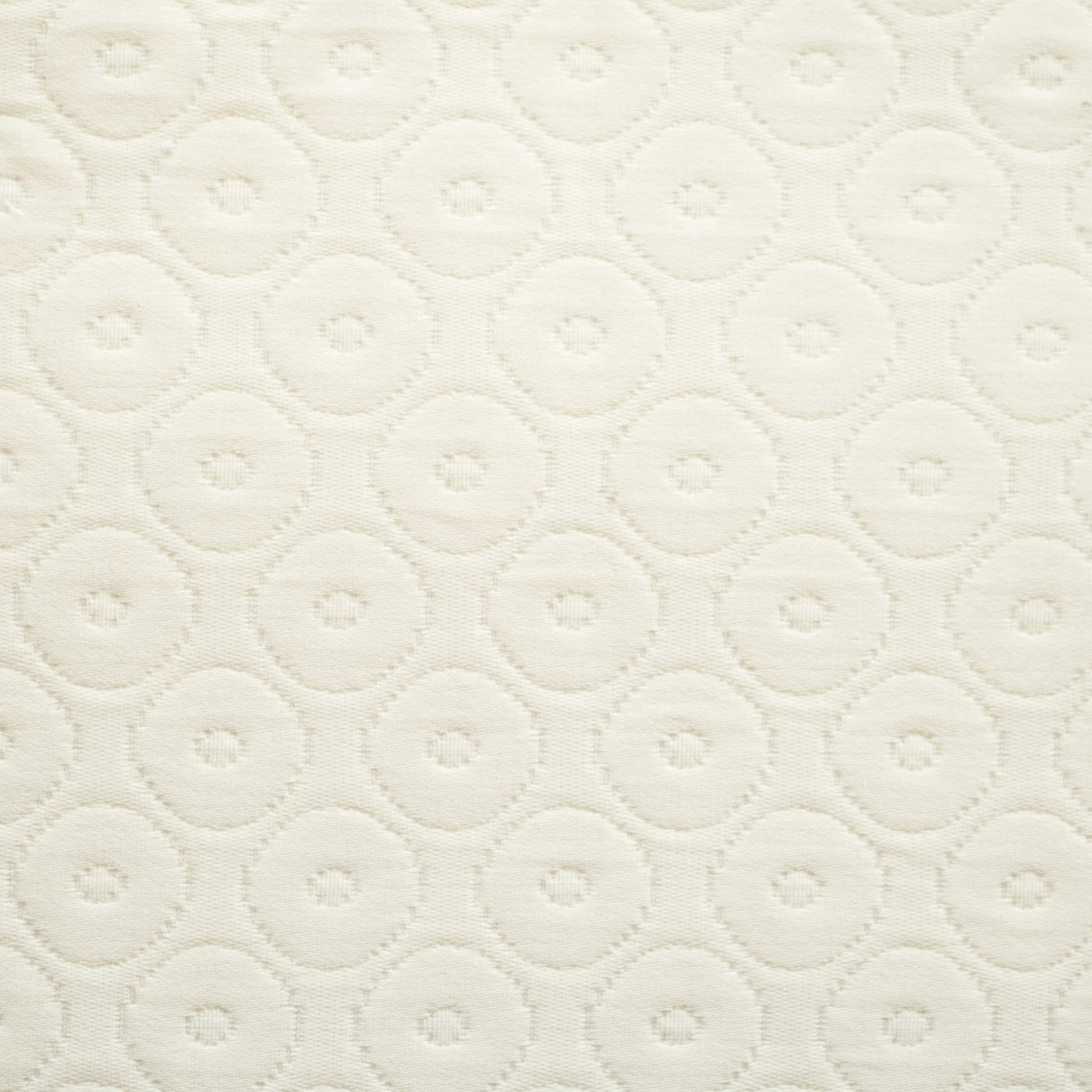 Close-up of ivory quilted cotton with tonal circular dot pattern stitching.