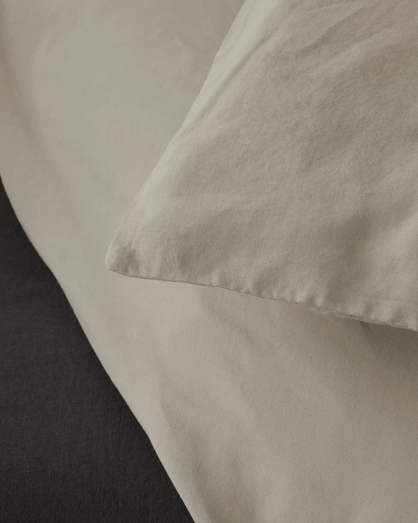 Close-up of Society Limonta Miro duvet cover corner in stone, showing soft washed cotton texture.