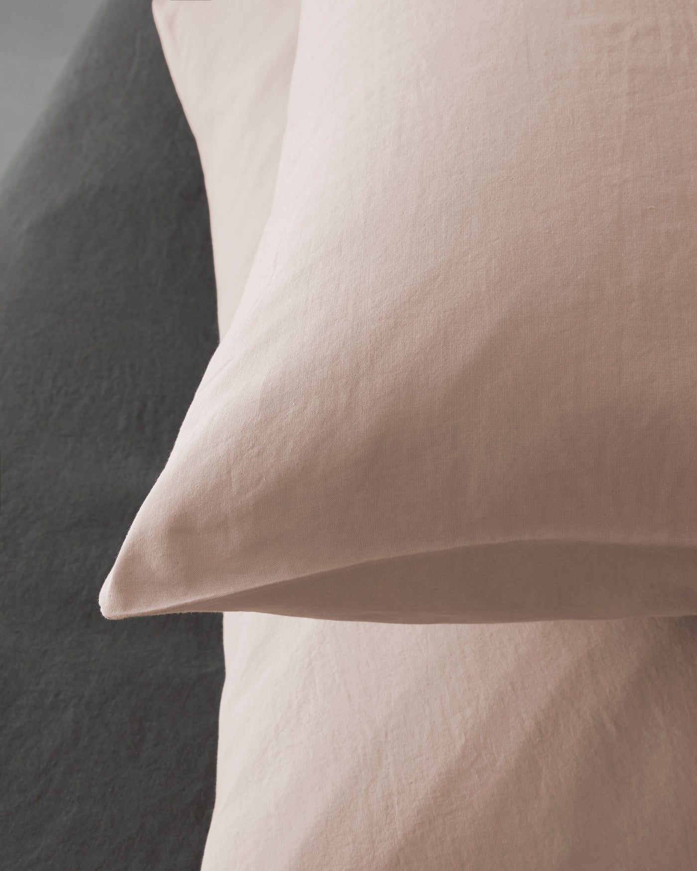 Close-up of Society Limonta Miro pillowcase set in blush against charcoal linen.