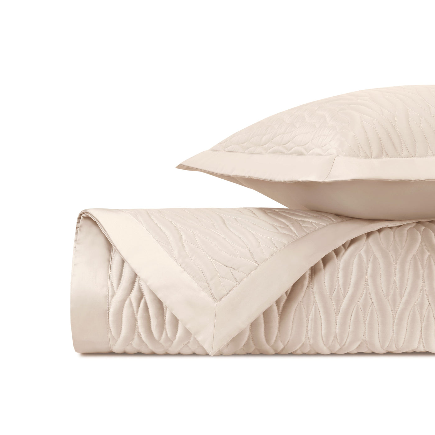 Close-up of ivory quilted fabric with flowing wave pattern and satin border trim.