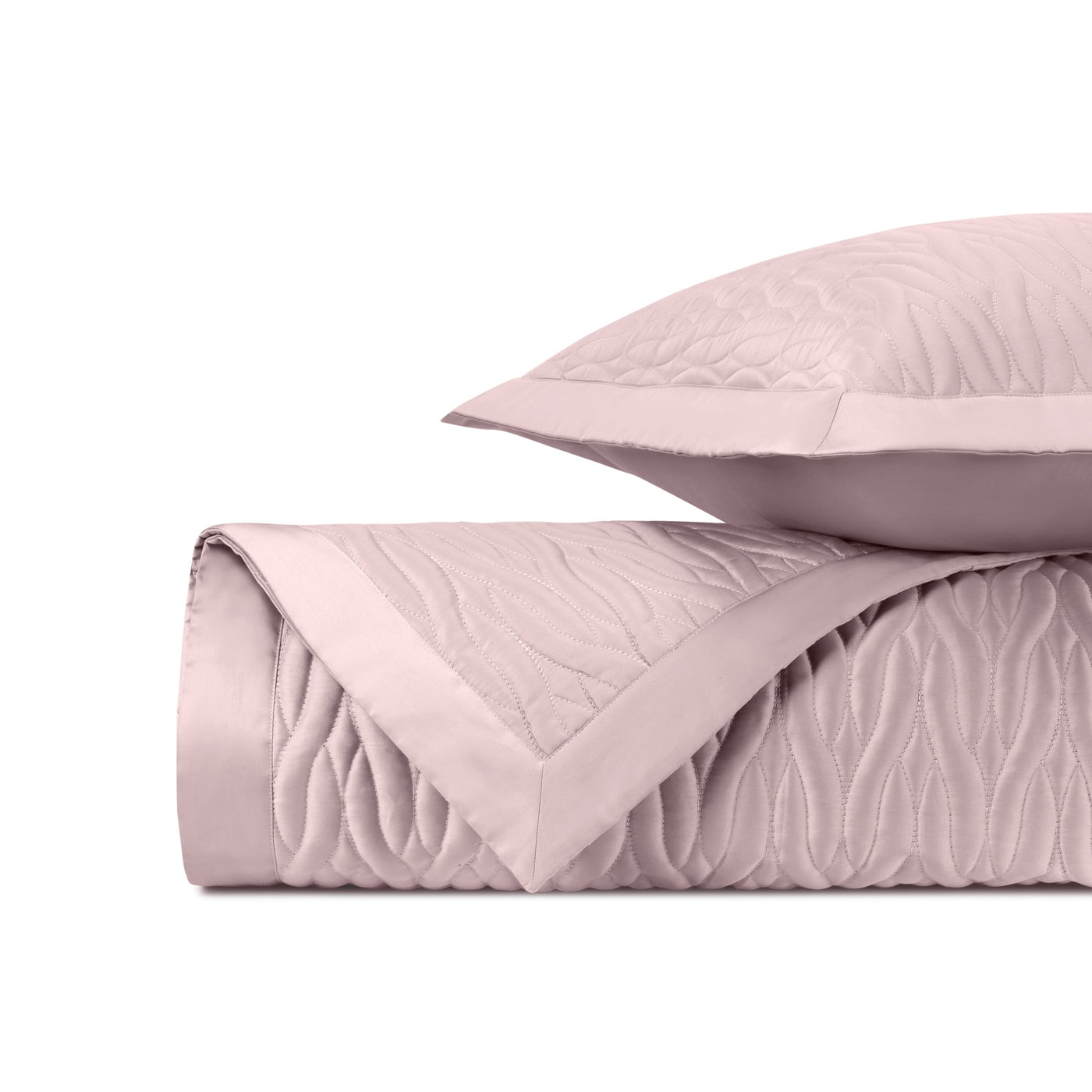 Close-up of blush quilted texture with flowing wave pattern and satin border trim.