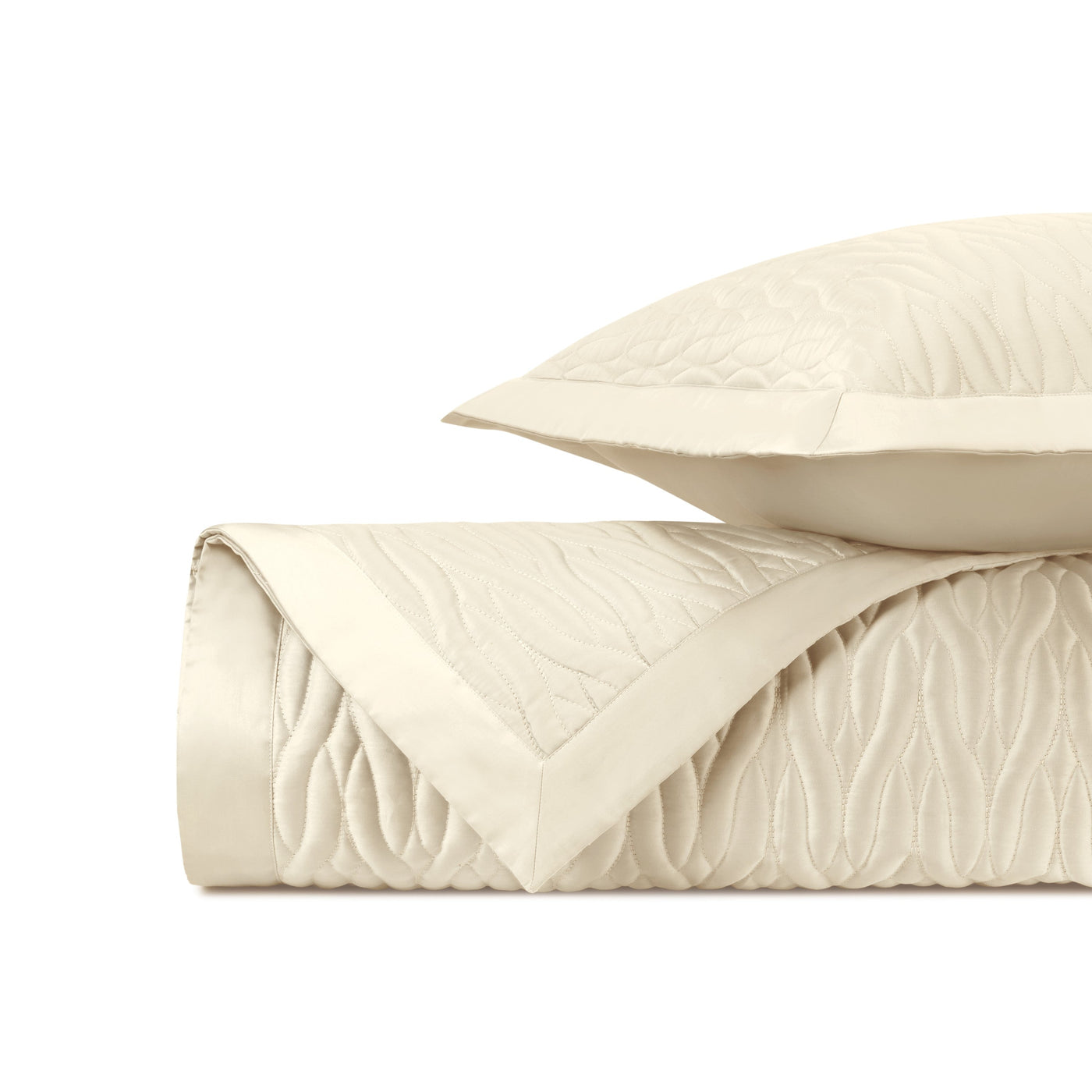 Close-up of ivory quilted fabric with flowing wave stitching pattern and flat border edge.