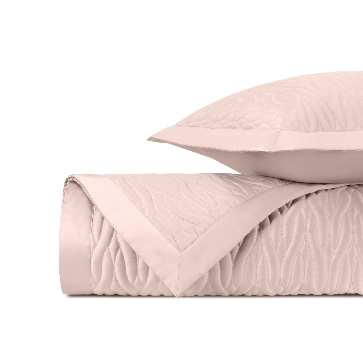 Close-up of blush quilted satin with flowing wave stitch pattern and flat border trim.