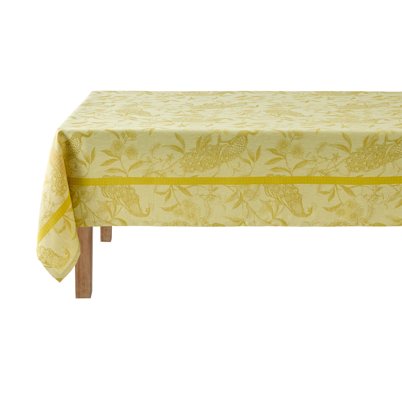 Close-up of citron jacquard tablecloth with woven botanical and bird motif on wooden table.