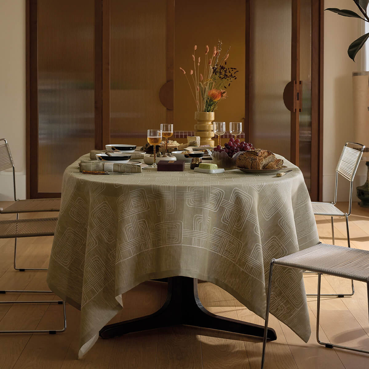 Le Jacquard Français Hôtel Particulier tablecloth in Green with arch jacquard pattern, styled on round dining table.