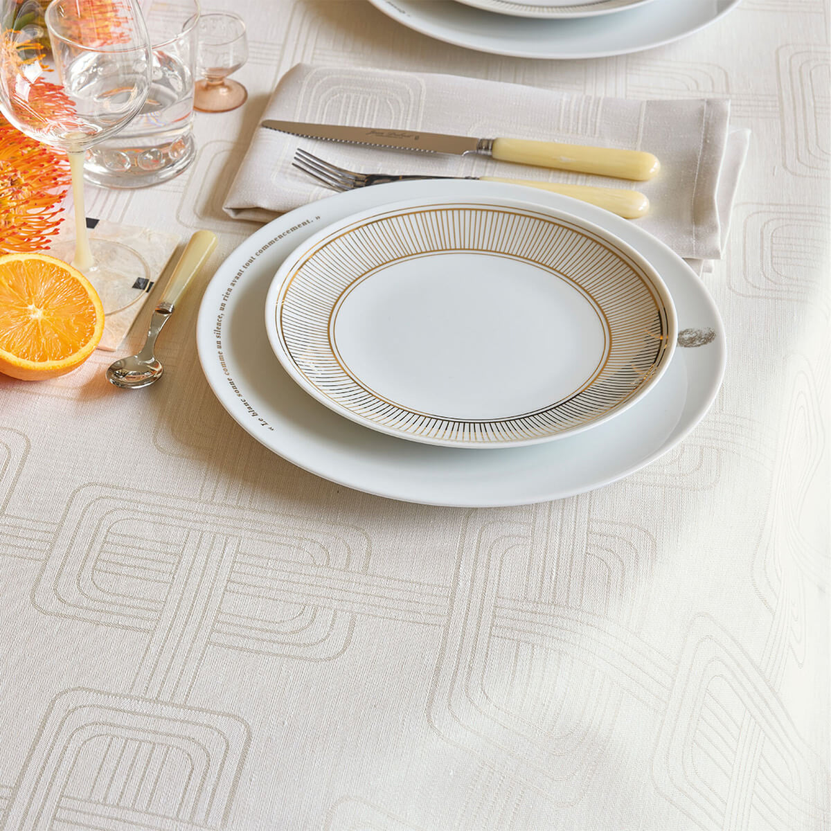 Le Jacquard Français Hôtel Particulier tablecloth in Gray, geometric jacquard weave styled with place setting.