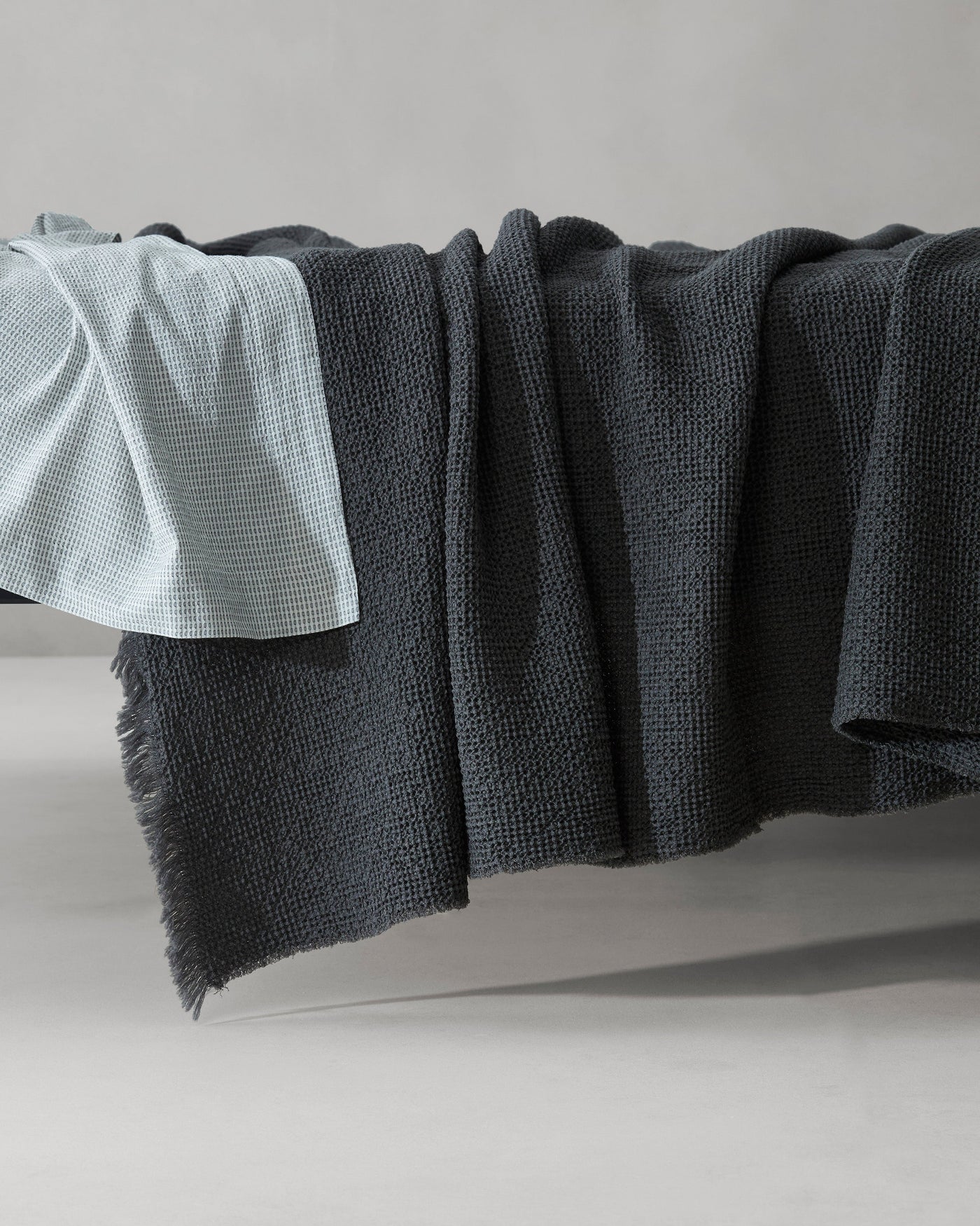 Close-up of Society Limonta Nid blanket in slate, showing fringe hem and textured weave.
