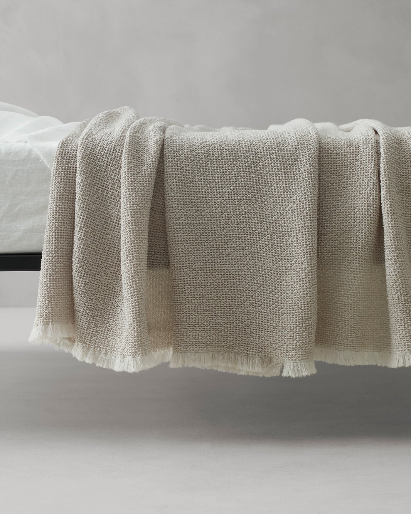 Close-up of Society Limonta Nid blanket's woven texture and ivory fringe hem.