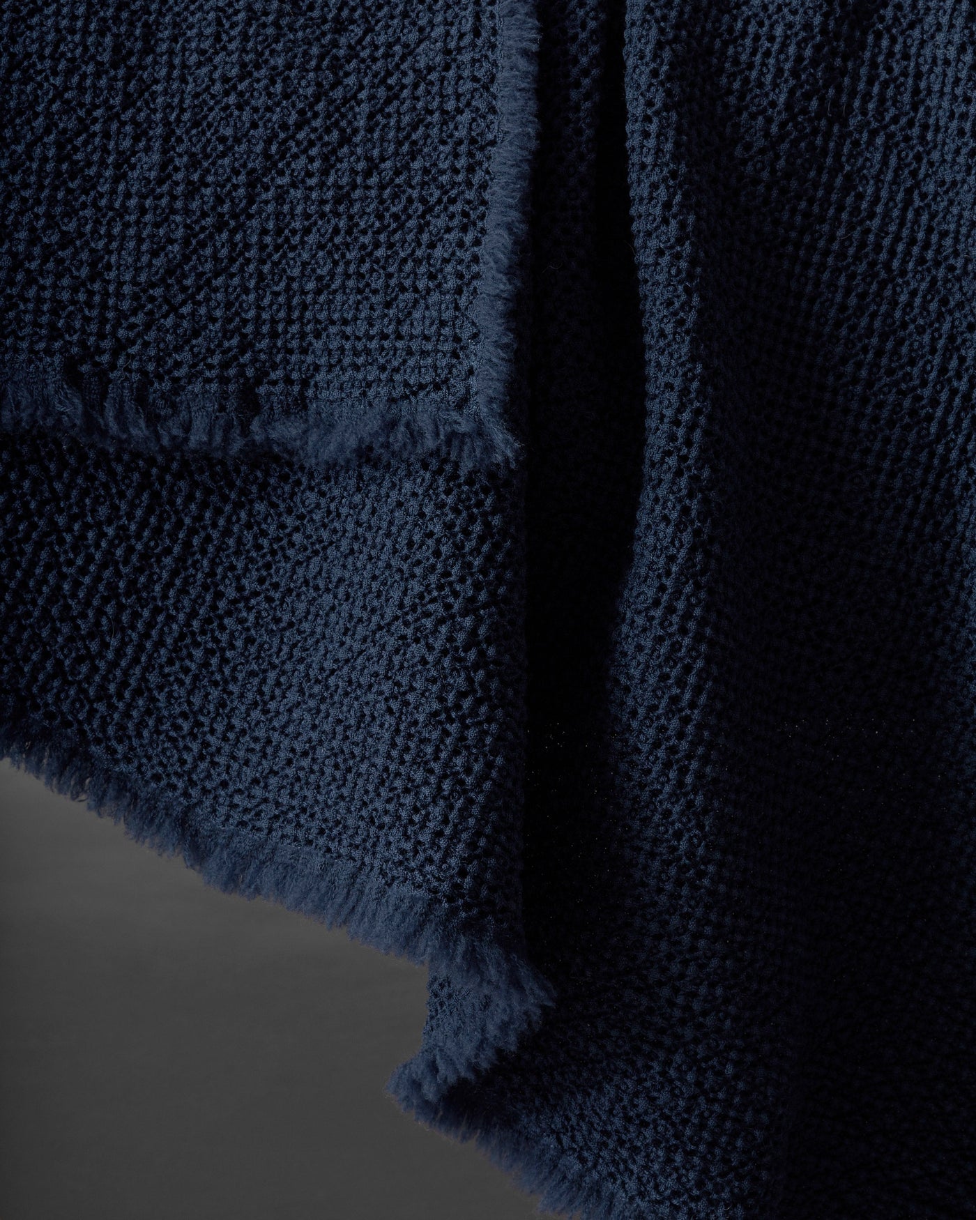 Close-up of Society Limonta Nid blanket's midnight blue textured weave and frayed edge detail.