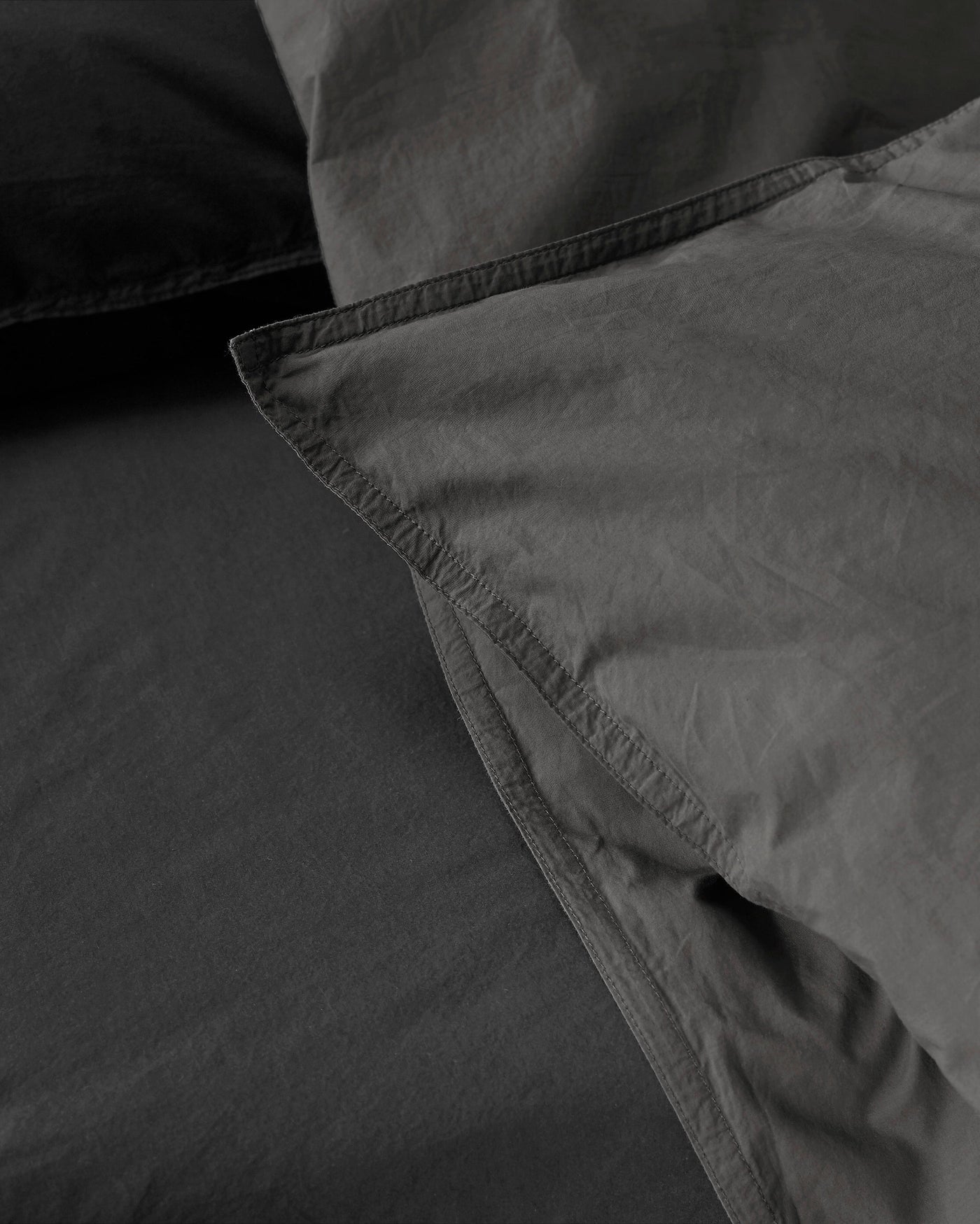 Close-up of Society Limonta Nite duvet cover hem detail in charcoal washed cotton.