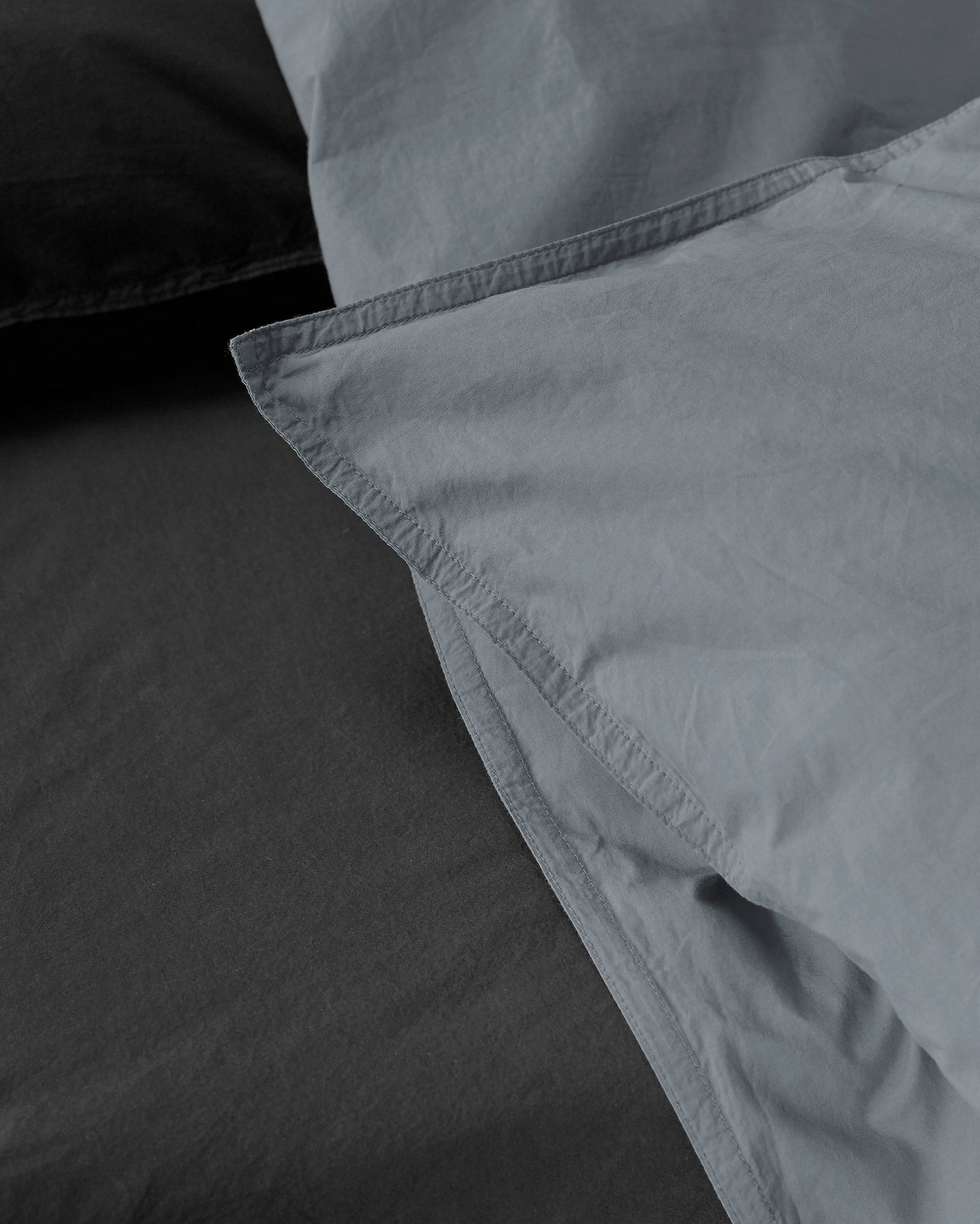 Close-up of Society Limonta Nite duvet cover hem detail in slate and charcoal cotton.
