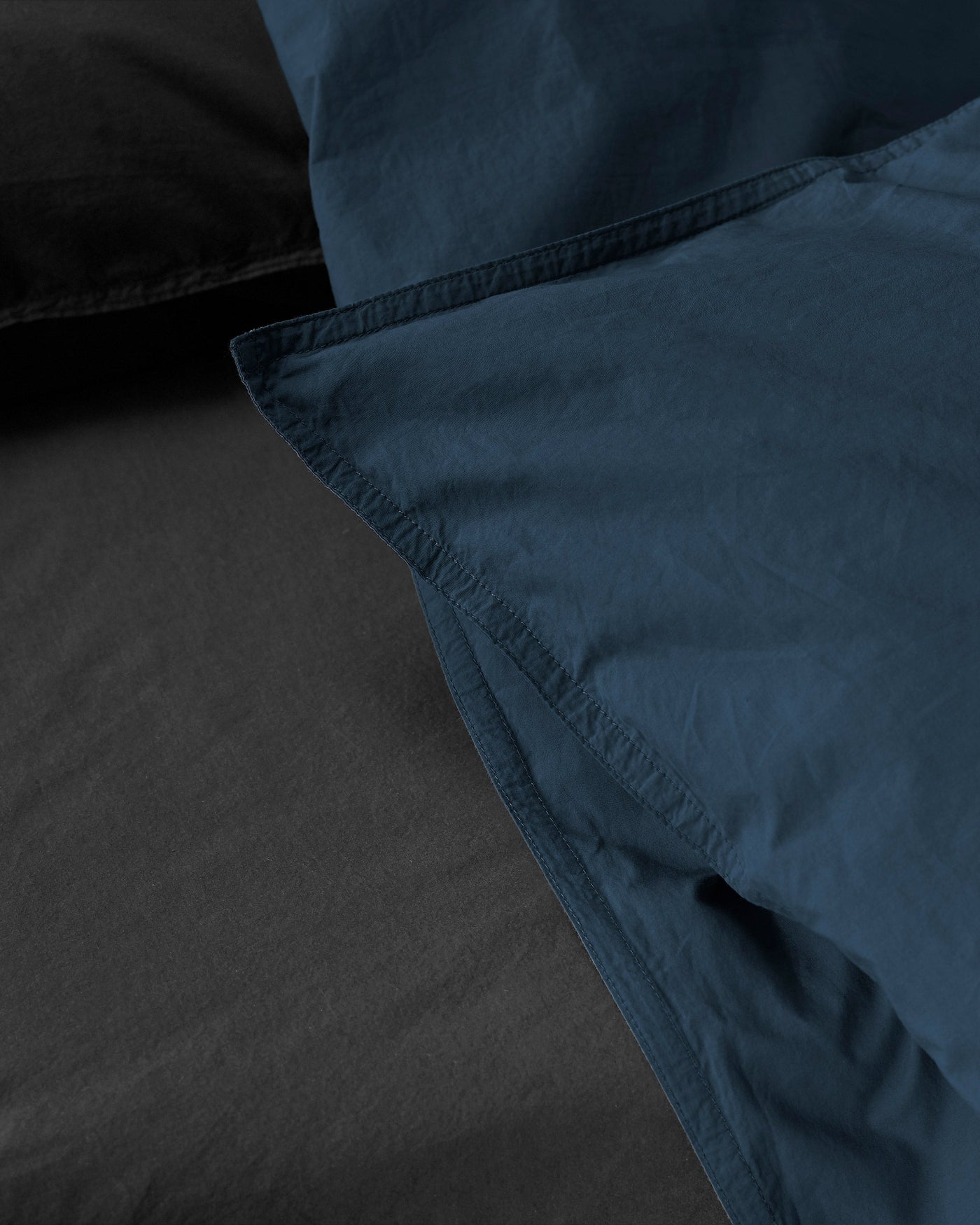 Close-up of Society Limonta Nite duvet cover corner seam detail in midnight blue.