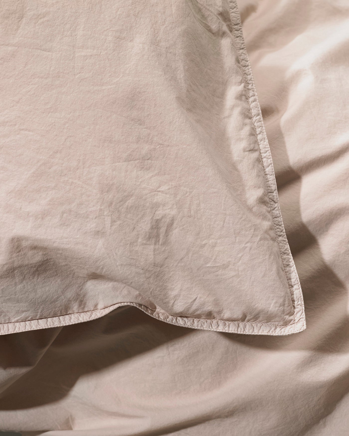 Close-up of Society Limonta Nite duvet cover corner with whipstitch edge detail in blush.