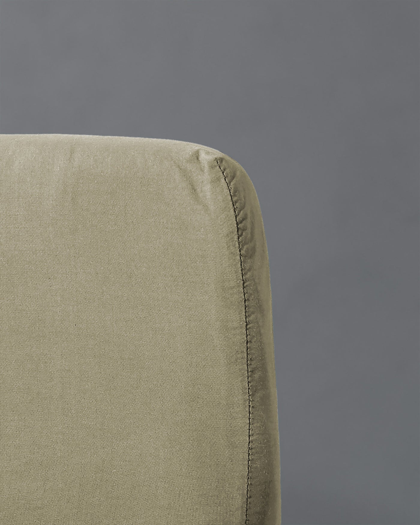 Close-up of sage fitted sheet corner showing stitched seam and relaxed linen texture.