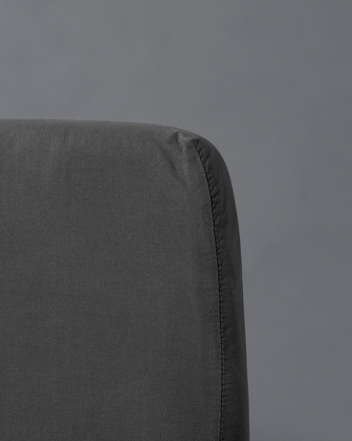 Close-up of charcoal fitted sheet corner showing tailored seam detail.