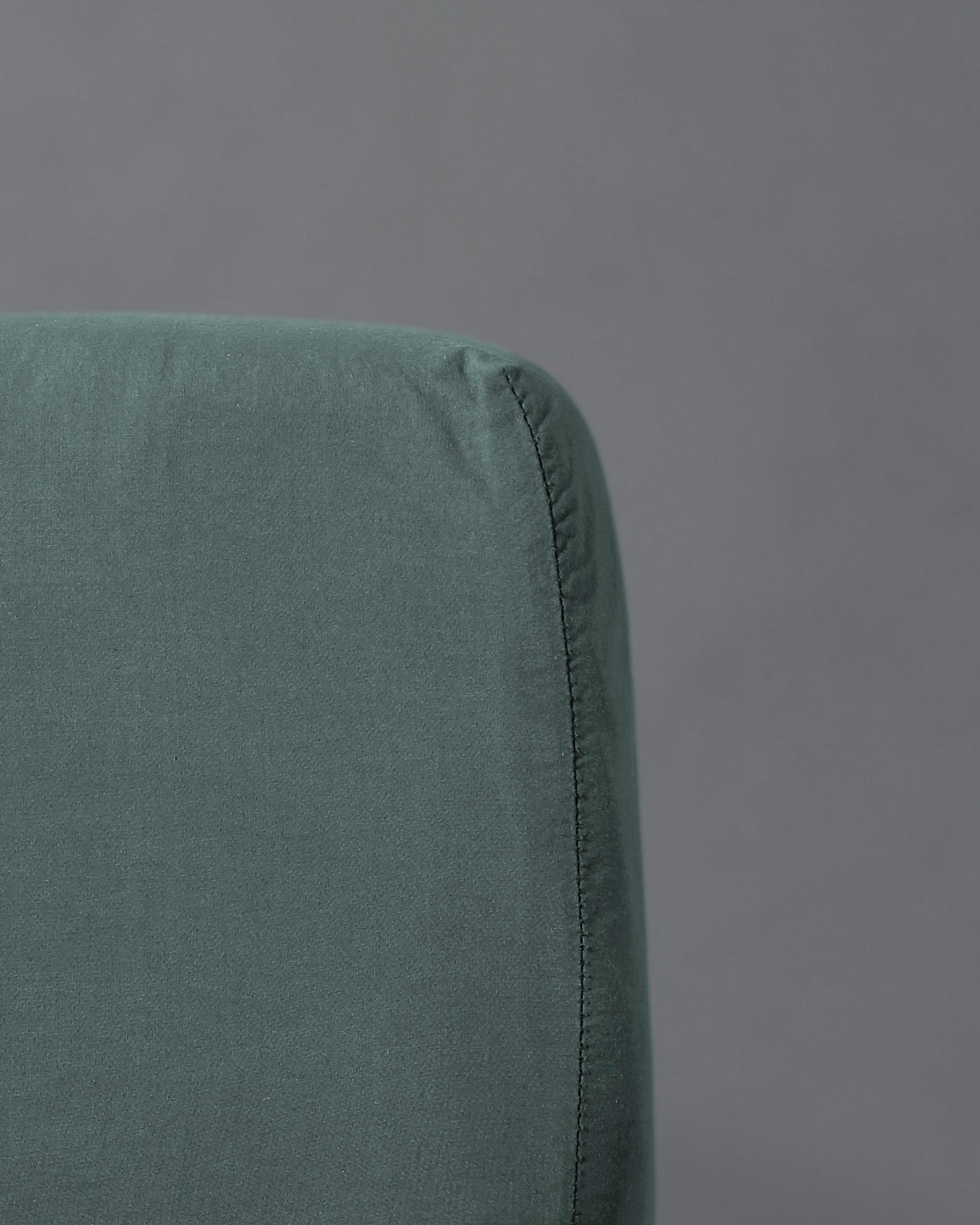 Close-up of Society Limonta Nite fitted sheet corner seam in sage green linen.