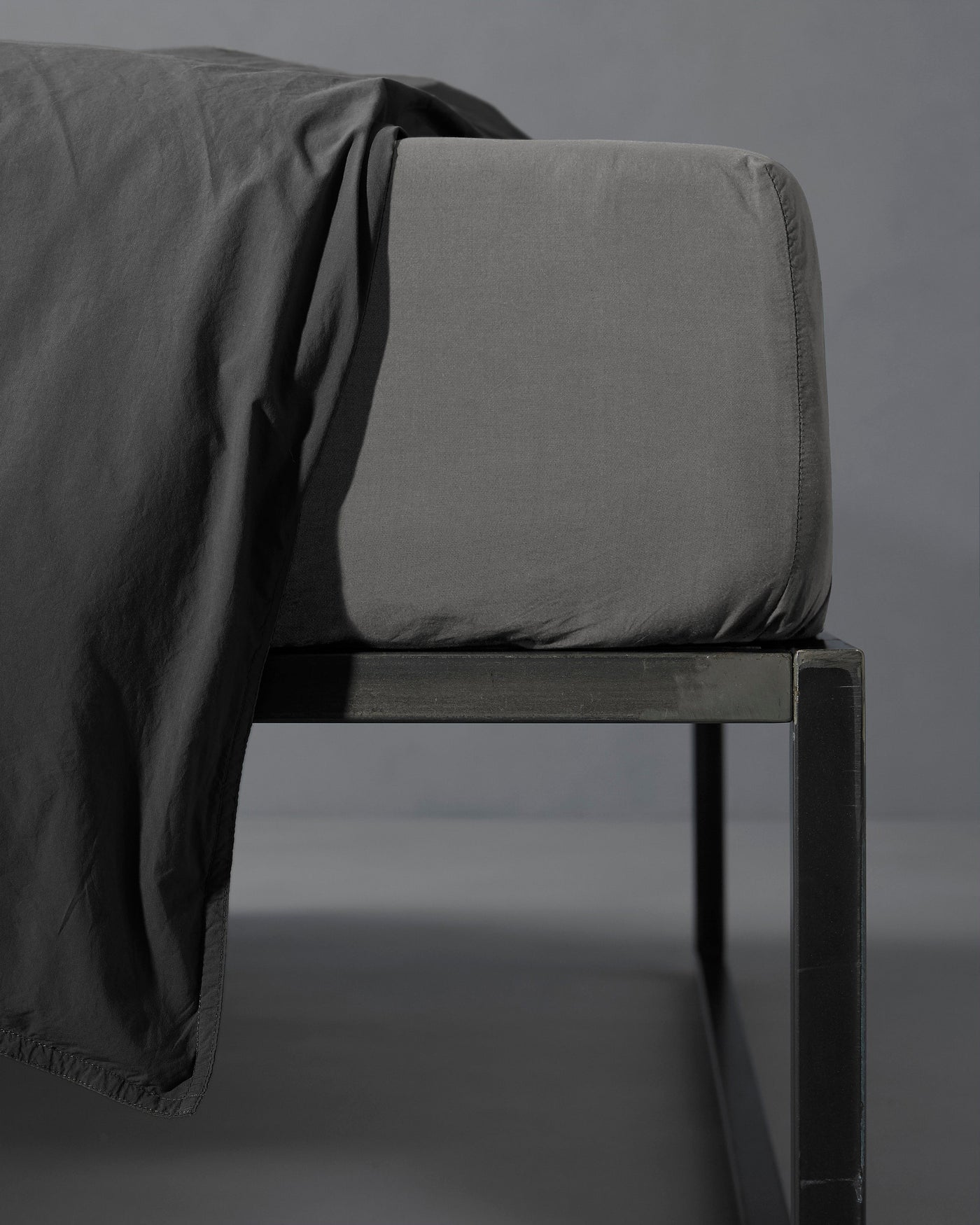 Close-up of Society Limonta Nite fitted sheet corner in slate, fitted over mattress edge.