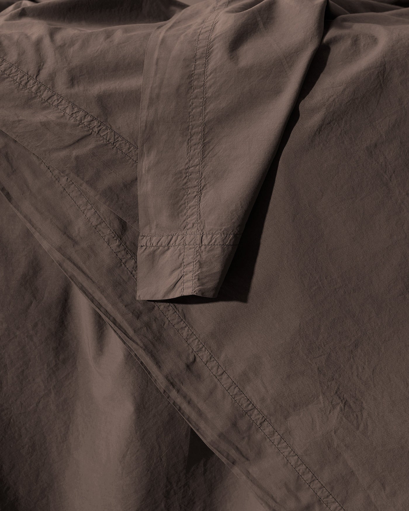 Close-up of Society Limonta Nite duvet cover hem detail in espresso cotton.