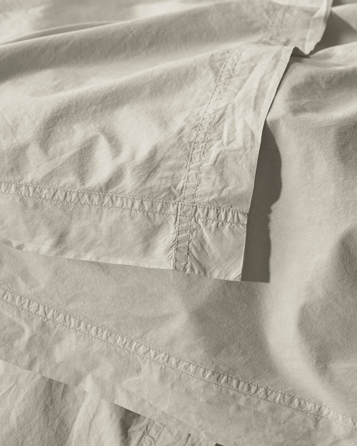 Close-up of Society Limonta Nite duvet cover hem with tonal embroidered stitching detail.