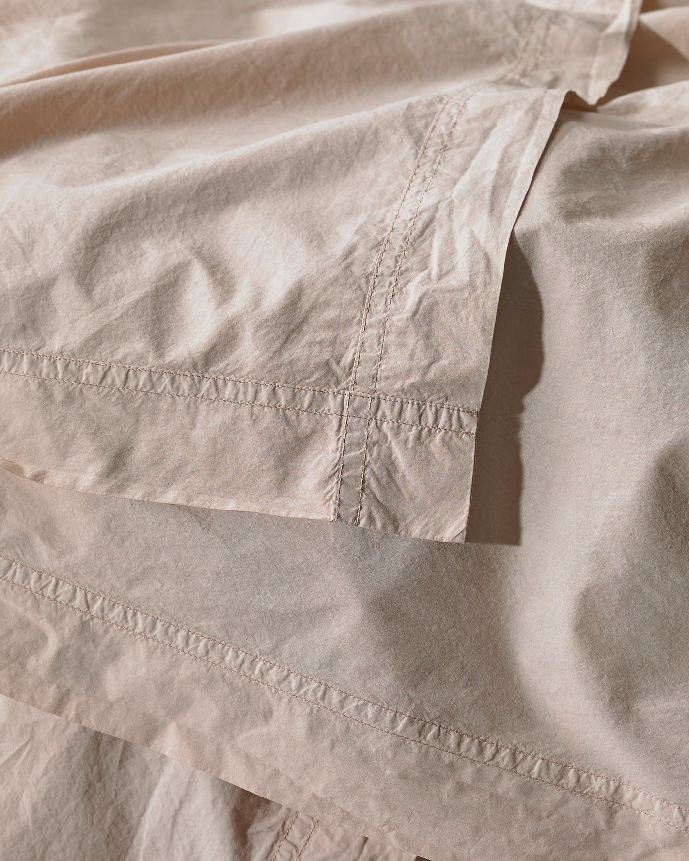 Close-up of champagne cotton duvet cover with tonal embroidered ladder stitch detail.