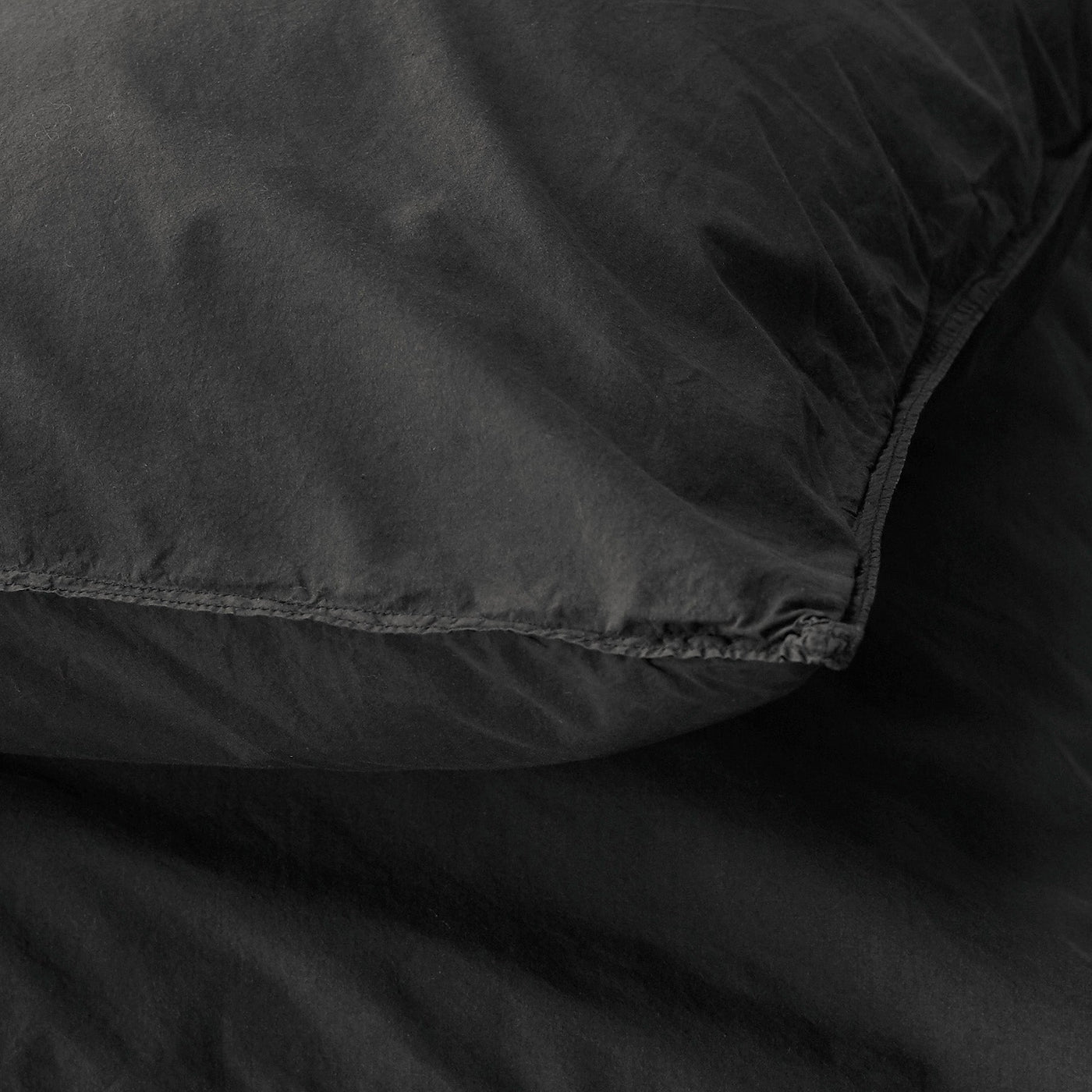 Close-up of Society Limonta Nite pillowcase corner seam in onyx washed linen.