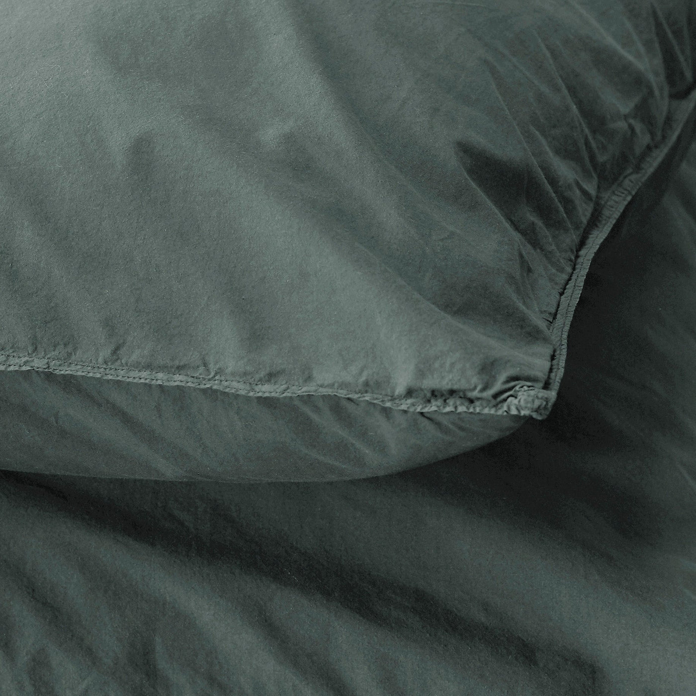 Close-up of Society Limonta Nite pillowcase seam detail in deep forest green washed cotton.