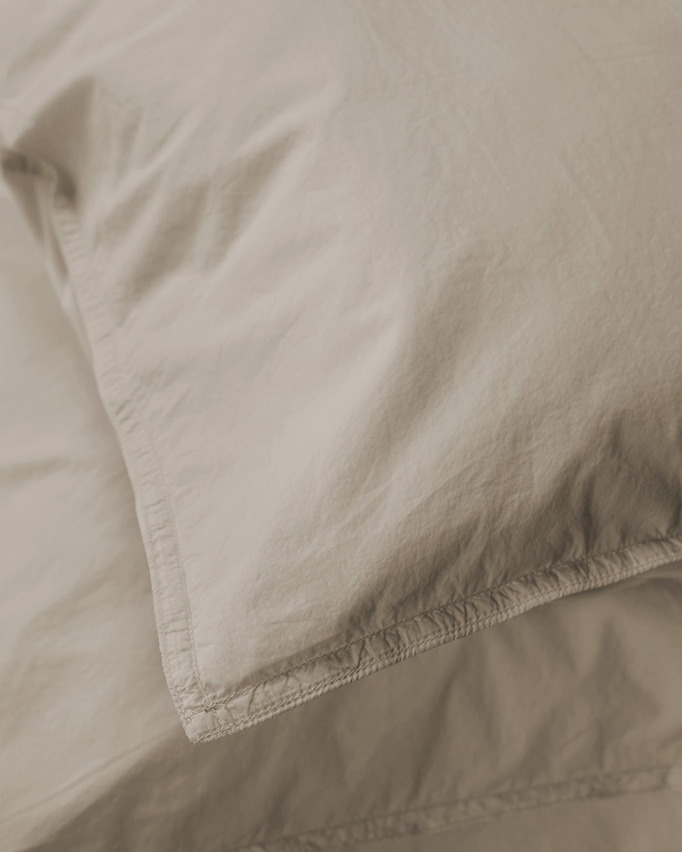 Close-up of Society Limonta Nite pillowcase corner seam in warm sand cotton.