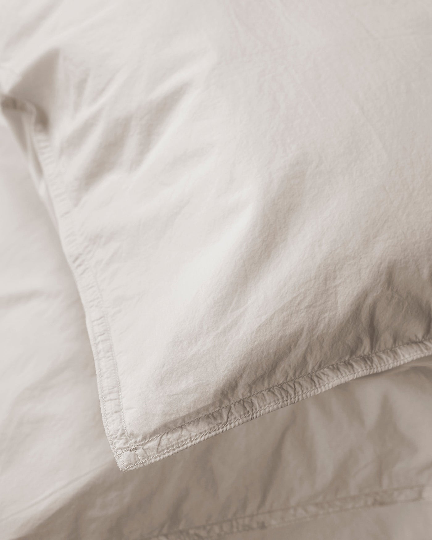 Close-up of Society Limonta Nite pillowcase corner seam in ivory cotton.