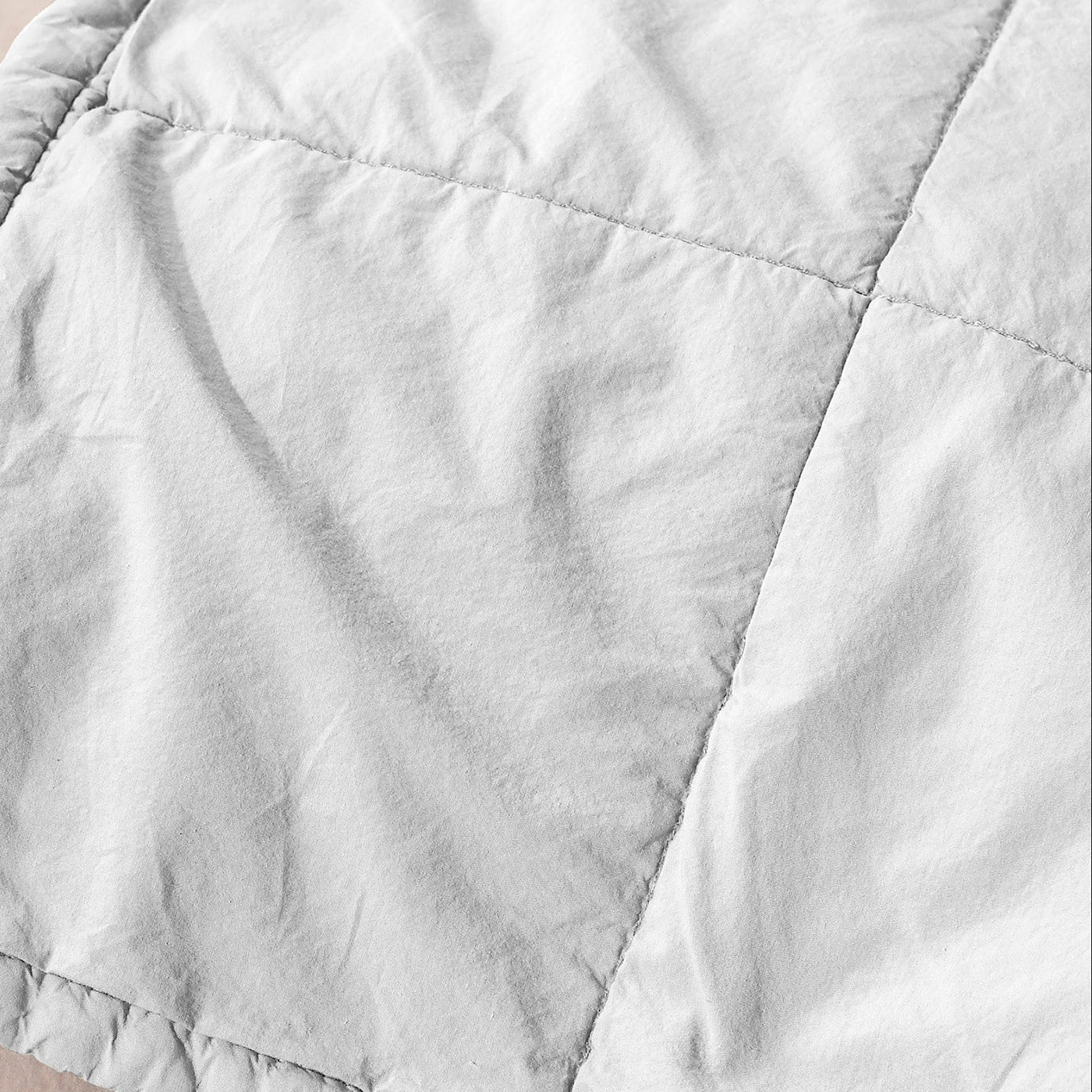 Close-up of Society Limonta Nite quilt in white, showing quilted grid stitching and soft washed linen texture.