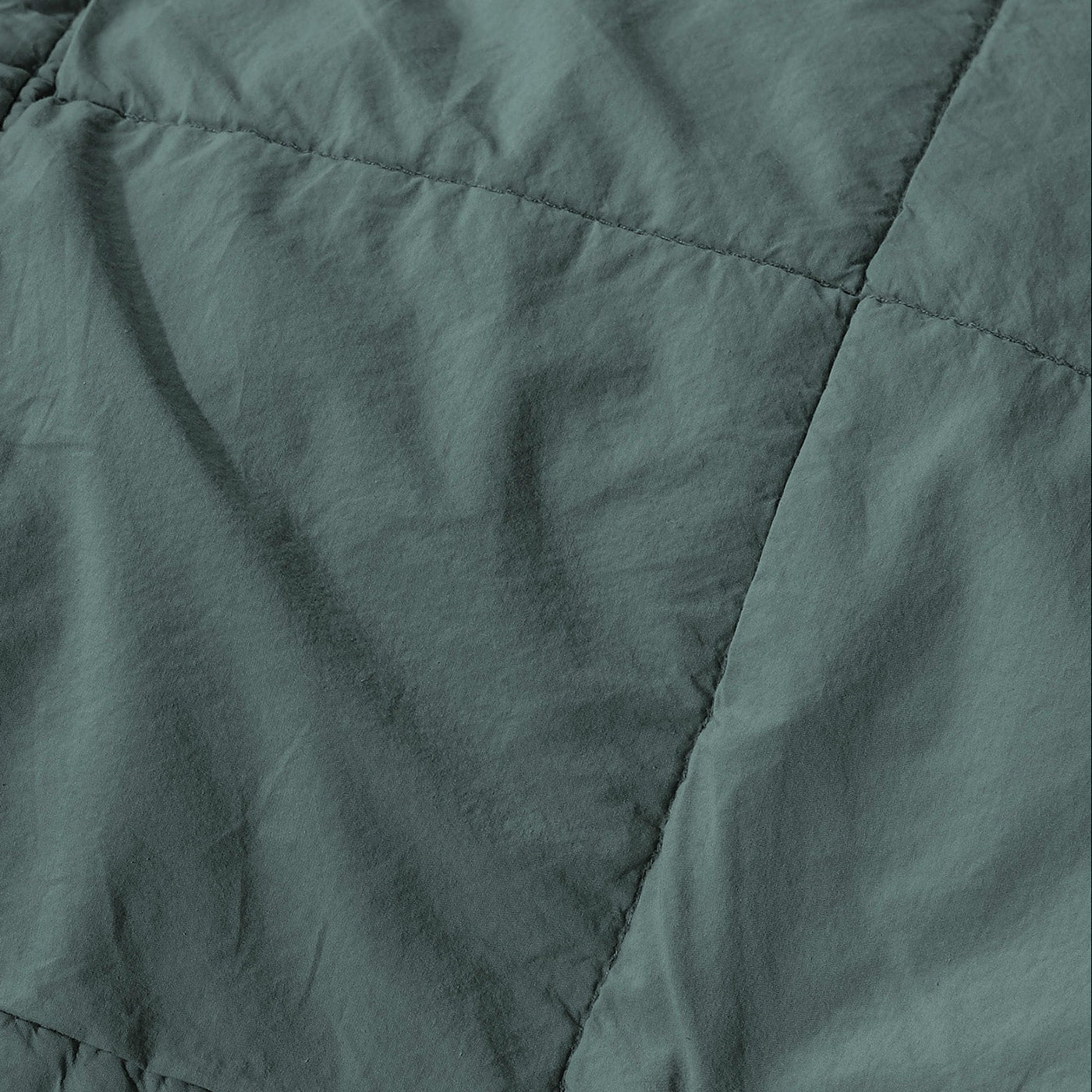 Close-up of Society Limonta Nite quilt in sage green, showing diamond stitching and texture.
