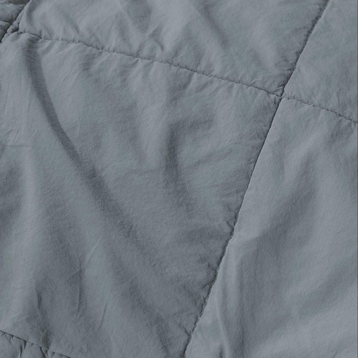 Close-up of Society Limonta Nite quilt in slate grey, showing diagonal quilted stitching detail.