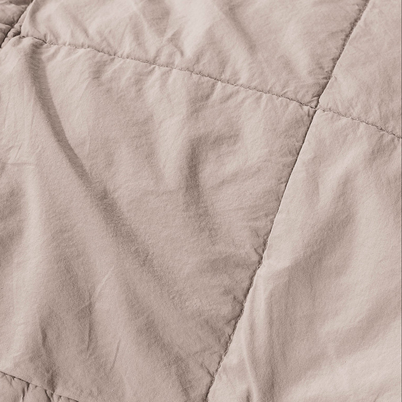 Close-up of Society Limonta Nite quilt in blush, showing diamond quilting stitching on washed linen.