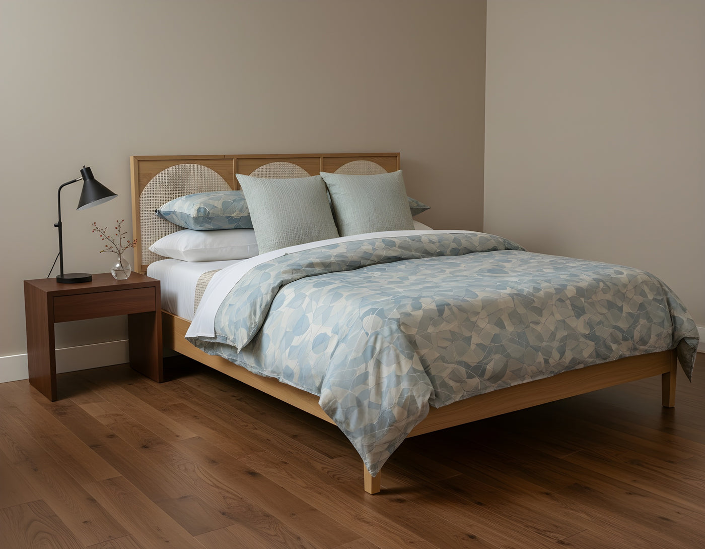 Bedroom with wooden bed, light blue patterned duvet, and nightstand with lamp.