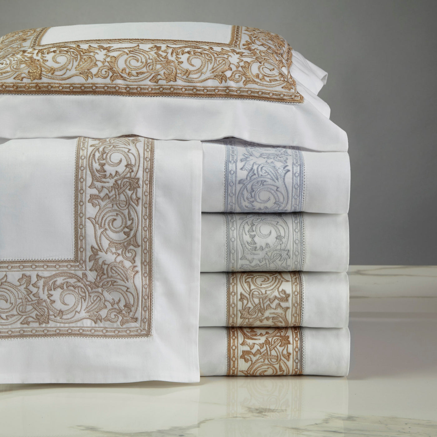 Home Treasures Paris pillowcases stacked in white with gold and silver baroque embroidery.