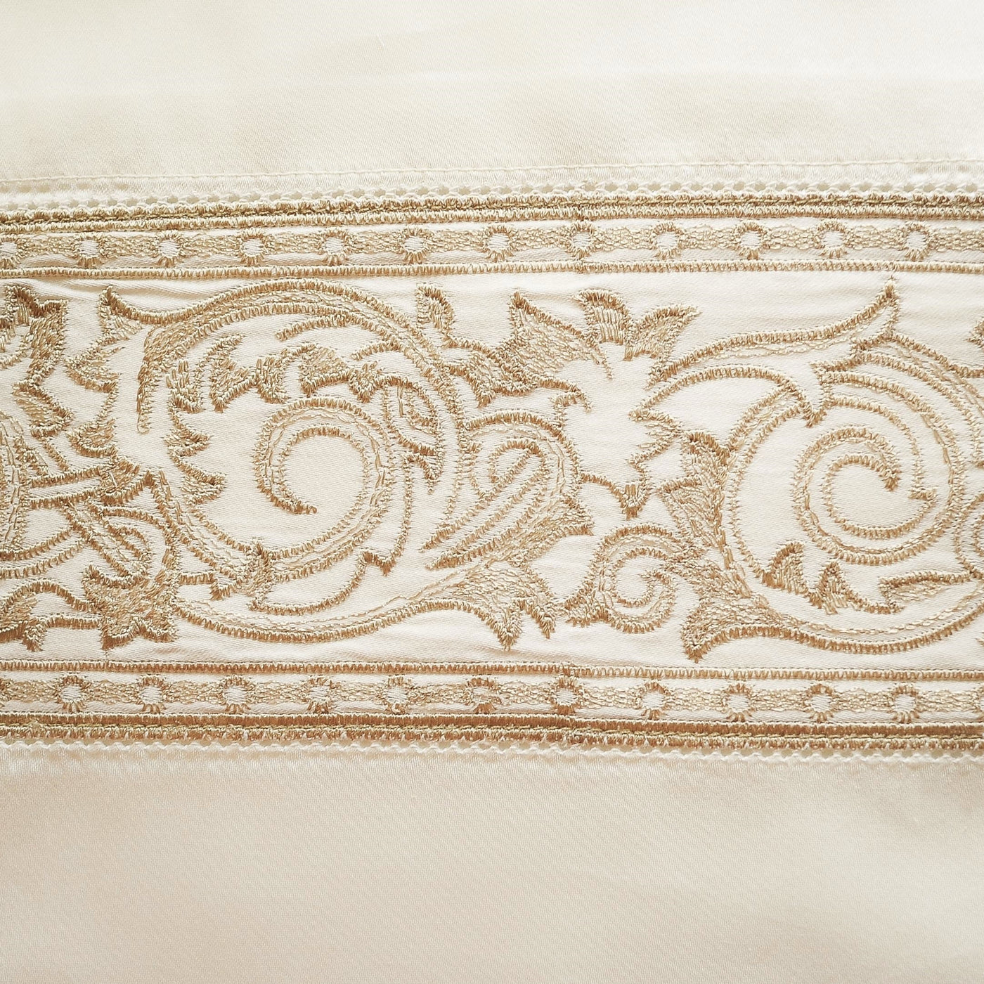 Close-up of champagne satin border with gold scrollwork embroidery detail.
