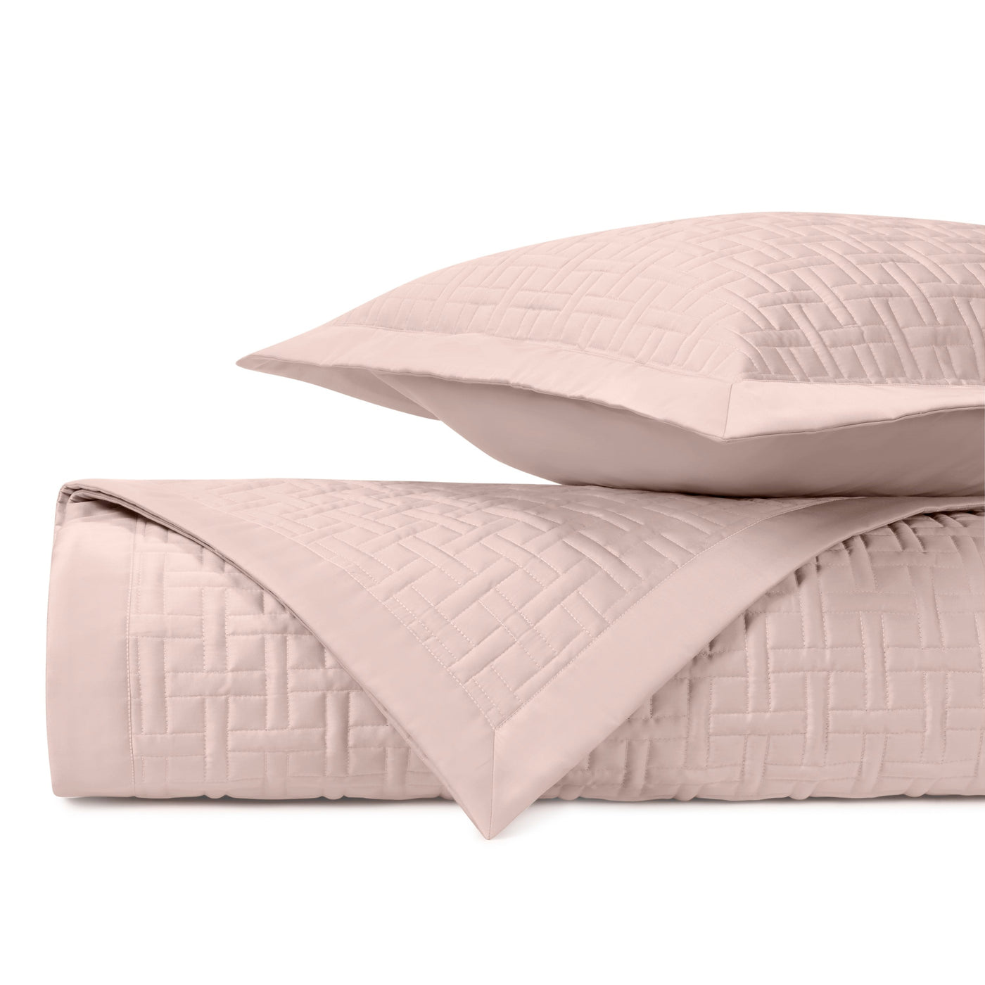 Close-up of blush Parquet quilted coverlet and sham showing basket-weave stitching detail.