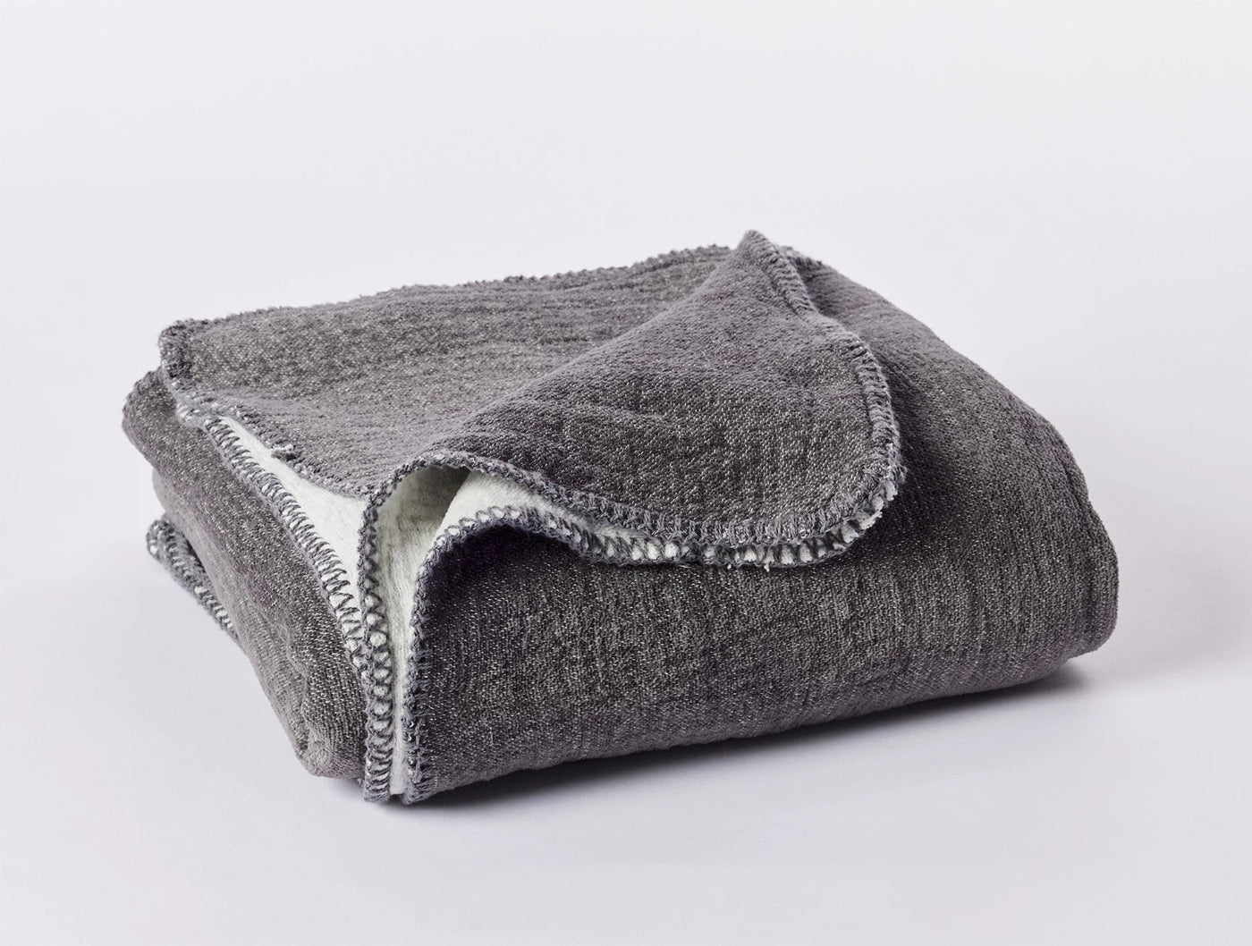 Folded charcoal Coyuchi Cozy Cotton Throw showing blanket-stitched edge detail.