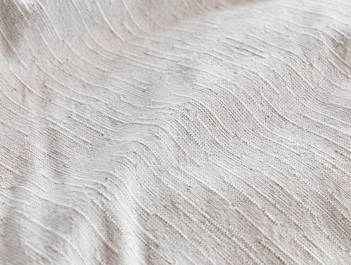 Close-up of Coyuchi Toro Canyon duvet cover showing ivory wavy textured linen weave.