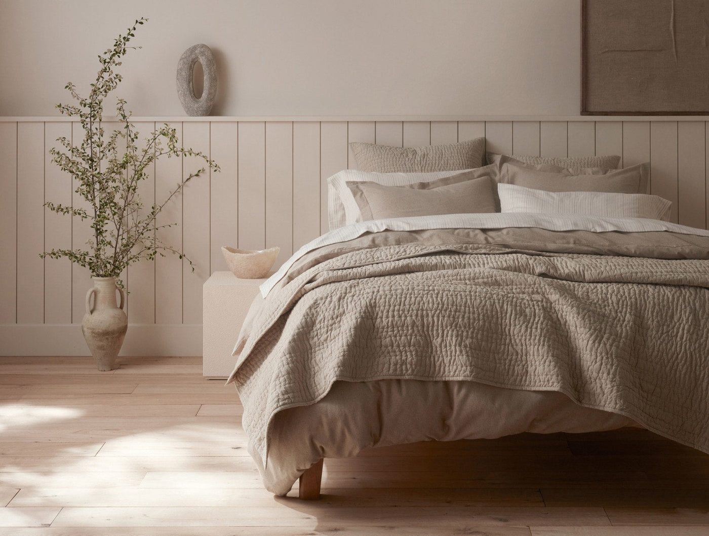 Close-up of a neutral bedroom styled with Coyuchi Channel Handstitched shams in warm oatmeal tones.